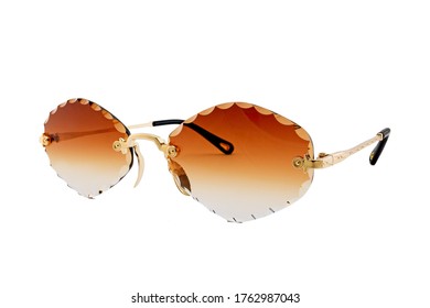 Rimless sunglasses and orange gradient rhomboid shaped lenses   gold thin frames isolated white background  Side view 
