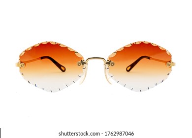 Rimless sunglasses and orange gradient rhomboid shaped lenses   gold thin frames isolated white background  Front view 