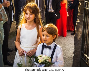 Ring Bearer And Flower Girl At Summer Wedding Near Church. Italy