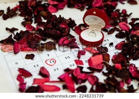 The ring box is placed on the calendar. Valentine's Day is marked on the calendar in red. Marriage proposal on Valentine's Day