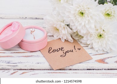 Ring in gift box and a bouquet of chrysanthemums. Beautiful white flowers, engagement ring and love message. Valentines Day, love and romance. - Powered by Shutterstock