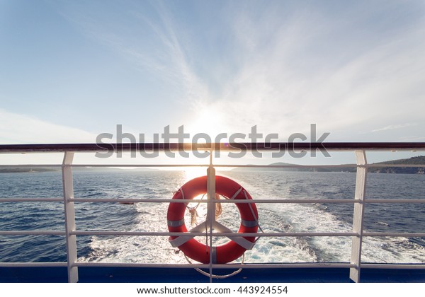 Ring life boy on big\
boat.Obligatory ship equipment.Personal flotation device.Prevent\
drowning.Orange lifesaver on the deck of a cruise ship.Traveling to\
an island