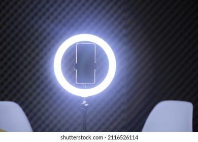 Ring Light With Smarthphone And Two White Chairs