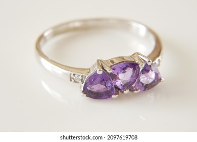 ring with lilac stone amethyst and white diamonds around, jewerly shop, pawnshop concept, closeup