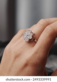 A ring in the shape of a four-leaf clover with precious stones on the finger. An elegant decoration that emphasizes style and luxury.