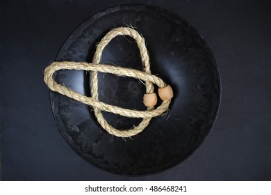 Ring Toss Game. Rope With Wooden Rings In Black Dish On A Black Background