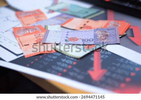 Ringgit Malaysia with graph falling down shows depreciation of currency