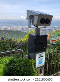 Ringgit Malaysia RM for tourist binocular viewing. Grey steel.  Glorious panoramic views of Penang from the top of the Penang Hill or Bukit Bendera. Clear weather. Breeze green. Malaysia. July 2022