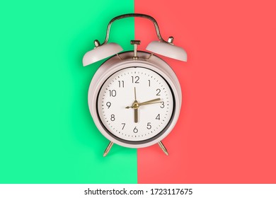Ringing twin bell vintage classic alarm clock Isolated on red and green pastel colorful trendy background. Copy space available