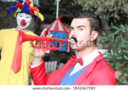 Ringmaster playing the trumpet in the circus

