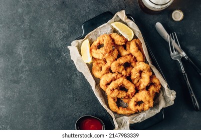 Rings of squid with lemon and beer on a black background. Snack to beer. Top view with copy space - Shutterstock ID 2147983339