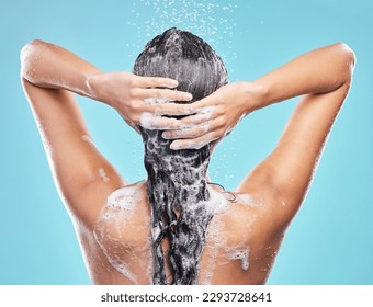 Rinsing it out. Shot of an unrecognizable woman washing her hair in the shower against a blue background. - Powered by Shutterstock