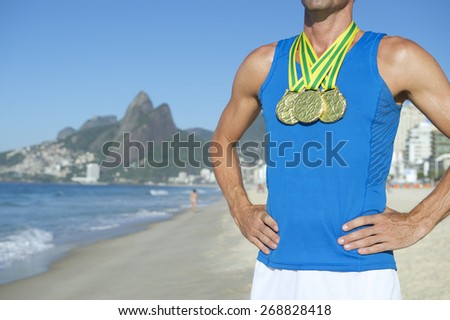 Rio 2016 first place athlete wearing gold medals standing outdoors on Ipanema Beach Rio de Janeiro Brazil 