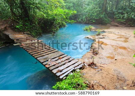 Rio celeste and small wooden bridge Tenorio national park Costa Rica