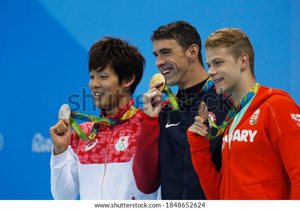 Rio de Janeiro, Brazil 08/09/2016: Michael Phelps\
gold medal at Rio 2016 Olympic Games 200m butterfly swim podium.\
Japan\'s Masato Sakai silver, Hungary\'s Tamas Kenderesi bronze at\
Aquatic Stadium