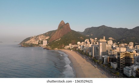 Rio de Janeiro, Brazil - April 4, 2019: Sunrise over Leblon beach in Rio de Janeiro with the Two Brothers mountain in the background and high rise buildings catching first light.