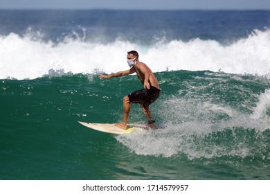  Rio de Janeiro, Brazil, April 25, 2020.
Surfer riding wave with coronavirus protection mask, at Barra da Tijuca beach, in the west area of ​​the city of Rio de Janeiro.