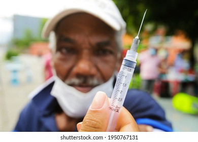 Rio De Janeiro,  Brazil April 05, 2021  A Nurse Shows A Man The Empity Syringe To Prove That The Dosage Of Corona Vac Vaccine Was Applied During A Mass Vaccination Event.