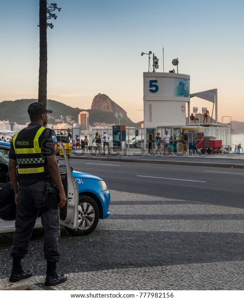Rio\
de Janeiro, Brazil - Dec 17, 2017: Local Brazilian policemen watch\
over locals and tourists in Copacabana, Rio de Janeiro, Brazil\
during a period the city is experiencing a\
crime-wave