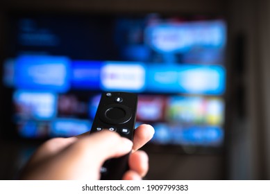 Rio de Janeiro  Brazil- February 3, 2021: amazon fire tv stick remote in hand with selective focus tv background. During the COVID-19
