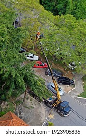 RIO DE JANEIRO, BRAZIL - FEBRUARY 22, 2021: Service Worker Pruning Tree Branches On A Platform Of A Crane Truck.                   