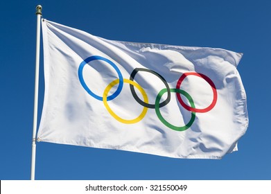 RIO DE JANEIRO, BRAZIL - FEBRUARY 12, 2015: An Olympic flag flutters in the wind against bright blue sky. 