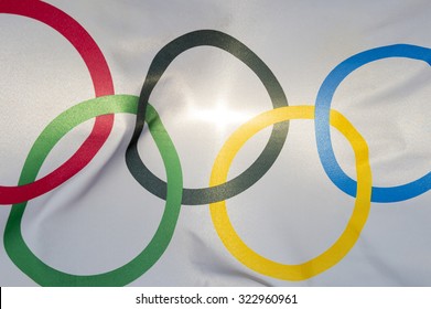 RIO DE JANEIRO, BRAZIL - FEBRUARY 12, 2015: An Olympic flag flutters in the wind backlit against bright sun. 