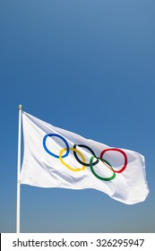 RIO DE JANEIRO, BRAZIL - FEBRUARY 12, 2015: An Olympic flag flutters in the wind against bright blue sky. 