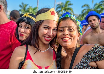 RIO DE JANEIRO, BRAZIL - FEBRUARY 28, 2017: Young Women Wearing Costumes Of Wonder Woman And Frida Kahlo With Unibrow Having Fun At Bloco Orquestra Voadora In Flamengo Park, Carnaval 2017