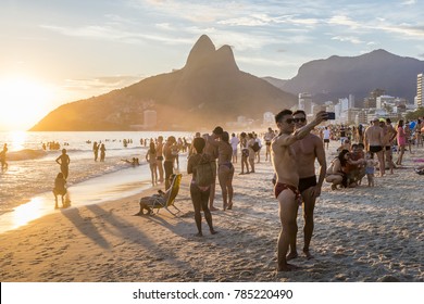 Rio de Janeiro, Brazil - Jan 1st, 2018: Two muscular men take a "selfie picture" at sunset in Rio de Janeiro's iconic Ipanema Beach