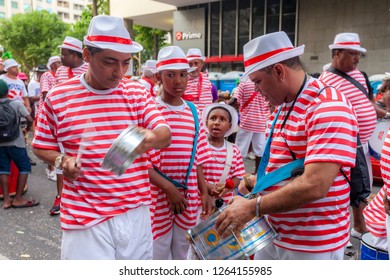 Rio De Janeiro, Brazil - March 3, 2014: Samba Drummers At A Carnival Block Party In The City Centre Of Rio De Janeiro With A Small Apprentice Boy In The Background