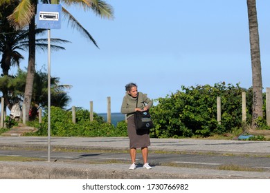 Rio De Janeiro, Brazil, May 11, 2020.
Elderly Woman Waiting For A Bus At Av Lucio Costa Stop On Barra Da Tijuca Beach.