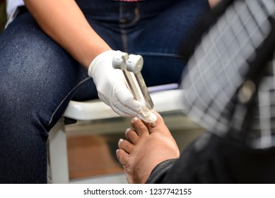 Rio de Janeiro, Brazil - november 22, 2018: Health professional examines the foot of a diabetic patient with a fork in a screening campaign.