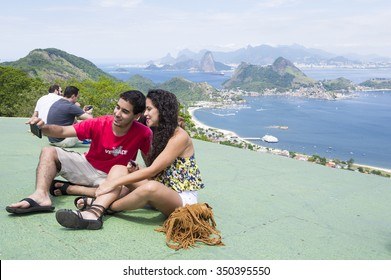 RIO DE JANEIRO, BRAZIL - OCTOBER 24, 2015: Young Brazilian Couple Takes A Selfie At A Scenic Overlook In Niteroi, Popular With Hang Gliding Enthusiasts.