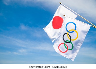 RIO DE JANEIRO - CIRCA MARCH, 2016: An Olympic and Japanese flag flutter together in the wind under bright blue sky.