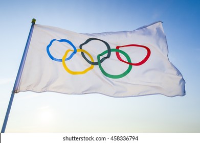 RIO DE JANEIRO - FEBRUARY 12, 2016: An Olympic flag flutters in the wind backlit against bright blue sky in celebration of the city hosting the Summer Games.
