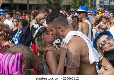 RIO DE JANEIRO - FEBRUARY 14, 2015:  A Young Brazilian Couple Who Just Met At A Carnival Street Party Kiss In The Crowd In Ipanema.