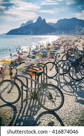 RIO DE JANEIRO - FEBRUARY 21, 2016: Bicycles Cast Shadows Above A Busy Beach Scene On Ipanema Beach.