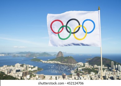 RIO DE JANEIRO - FEBRUARY 26, 2016: Olympic flag waves above the city skyline view of Sugarloaf Mountain and Guanabara Bay in celebration of the city hosting the Summer Games.