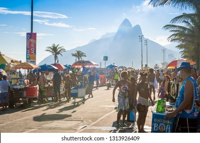 RIO DE JANEIRO - FEBRUARY 28, 2017: Unlicensed Brazilian Vendors Serve Drinks And Snacks To The Crowd Celebrating At A Carnival Street Party In Ipanema.