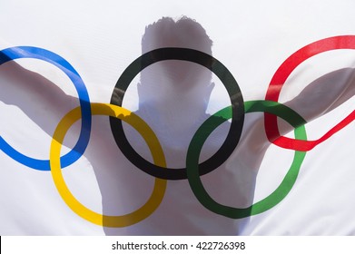 RIO DE JANEIRO - FEBRUARY 3, 2016: Shadow silhouette of athlete holding an Olympic flag in anticipation of the 2016 Summer Games.