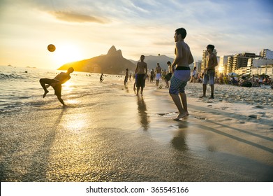 RIO DE JANEIRO - JANUARY 18, 2014: Groups of young Brazilians play keepy uppy beach football, or altinho, at sunset on the shore of Ipanema Beach at Posto Nove.