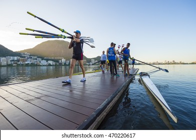 RIO DE JANEIRO - MARCH 14, 2016: After Practice, A Brazilian Rower Carries Oars Back To The Clubhouse At  Lagoa Rodrigo De Freitas Lagoon, A Venue For The Rio 2016 Olympic Games.