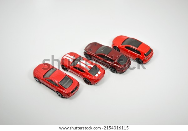 Teutônia, Rio\
Grande Do Sul, Brazil - May 02, 2022: Small amount of red tiny cars\
from top view on white\
background.