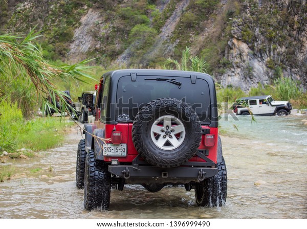 Rio Pilon, Nuevo\
Leon, Mexico. May 12, 2019.  All terrain vehicles crossing a river\
and having fun. Jeep.