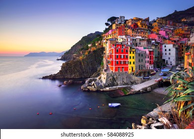 Riomaggiore village on cliff rocks and sea at sunset., Seascape in Five lands, Cinque Terre National Park, Liguria Italy Europe. Long Exposure