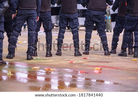Riot police practice crowd-control scenarios from protesters throwing officers with paint.