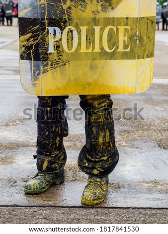 Riot police practice crowd-control scenarios from protesters throwing officers with paint.