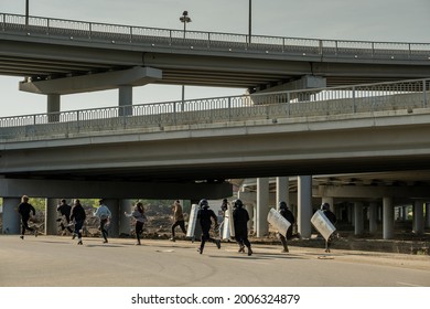 Riot Police With Shields Running For Young Law-breakers Under Bridges To Catch Them And Arrest