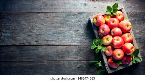 Ripe Apples In Wooden Basket On The Rustic Table
